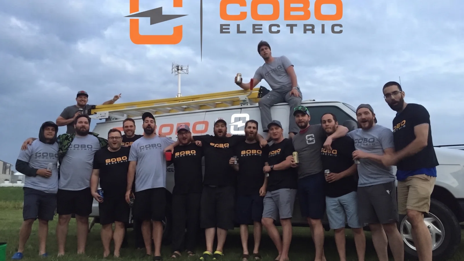 The Cobo Electric team gathered in front of a branded Cobo Electric work van